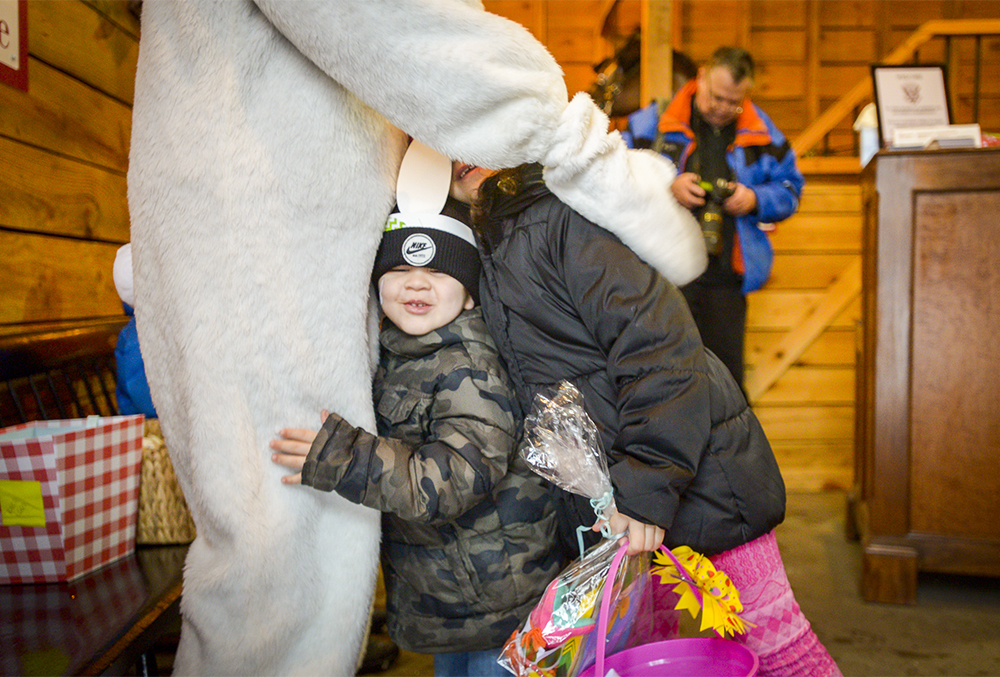 photograph of a child hugging the easter bunny's leg at the presidential egg roll easter event.