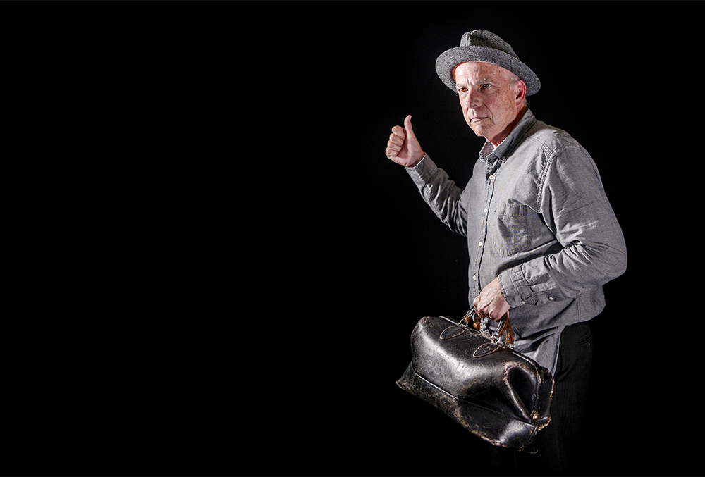 Photograph of a hitch hiker with a bag.