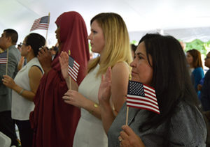 Photograph of a crowd of people holding small american flags in their hands.
