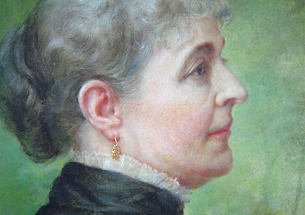 Oil on canvas by Lilly M. Spencer (Lilly Martin Spencer) of Caroline Scott Harrison in profile view. Spencer signature is in lower left (not visible when portrait is in frame). Many engravings and prints were made from this image of Caroline Harrison. She is wearing a dark dress with white lace trim at the high neck, gold earrings, and hair is pulled back in a bun. Background is green in varying dark to medium shades. Pat. date of 1885 on metal corner brackets of wooden stretcher.