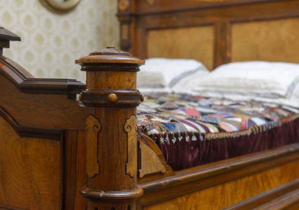 Original Harrison large rosewood and satinwood Renaissance Revival bed. Satinwood panel in tall head board. Large Egyptian medallion in center of head board that matches smaller medallions in chairs. The head board is 8 feet tall with squared feet. Squared urn design on foot board. Foot board has round massive legs. Ornamental pieces in medallions, scrolls, etched designs, etc.