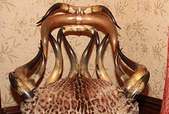 Several plaque on the back and arms of the chair convey the following: Top plaque: 