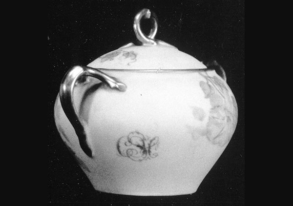 backside of the tea pot. shows a closer look at some of the floral patterning and twig shaped handle.