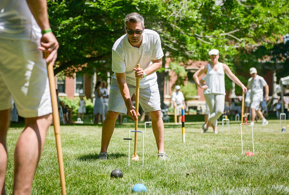photo of a crowd of people playing croquet on the presidential lawn on a summers day.